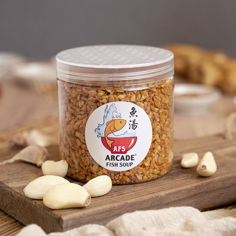 A jar of Arcade Fish Soup fried garlic with fresh garlic cloves